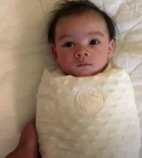 Tiny baby throws arms up after being unswaddled and it's too sweet